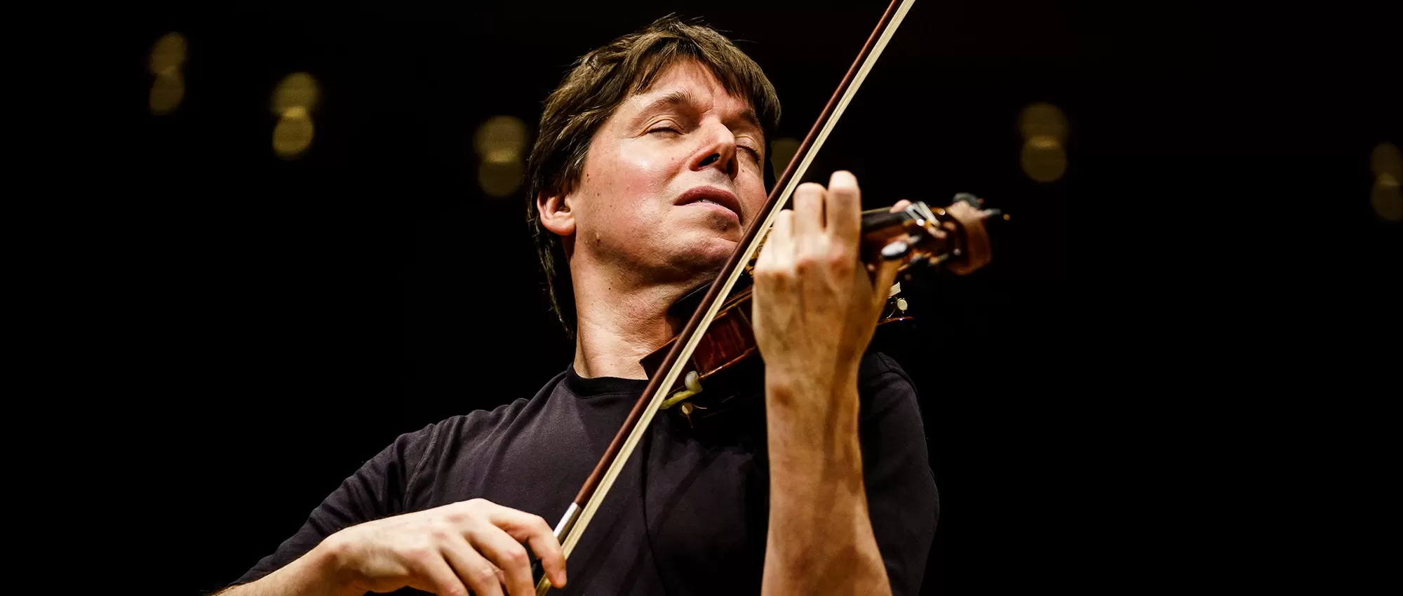 Violinist Joshua Bell holding his violin
