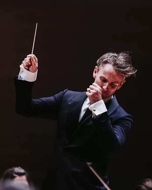 Alexander Shelley holding a baton