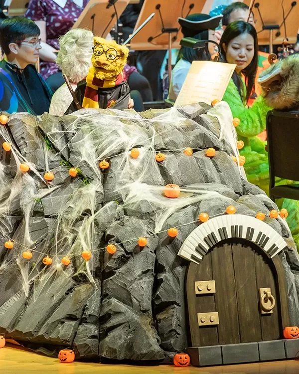 Leopold the Leopard puppet on stage with musicians of Pacific Symphony