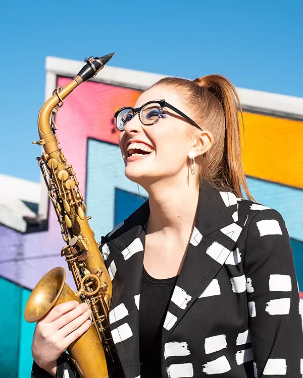 Alto saxophonist Jess Gillam against a colored background