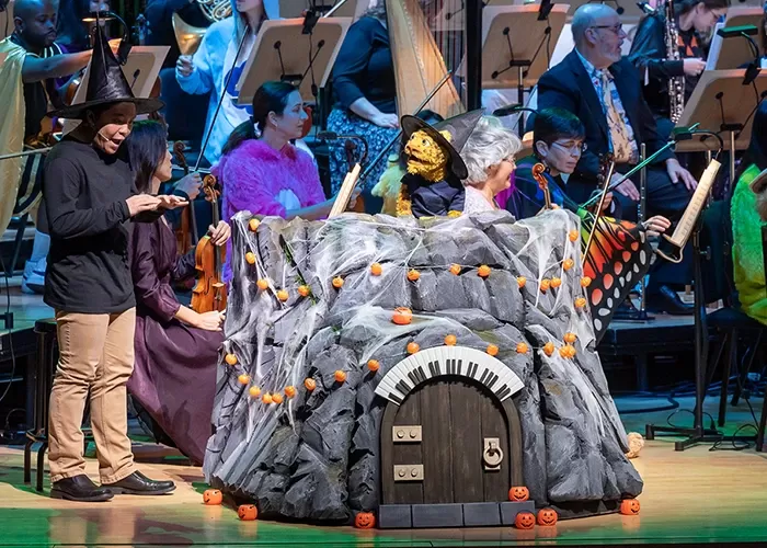 Leopold the Leopard puppet on stage with musicians of Pacific Symphony