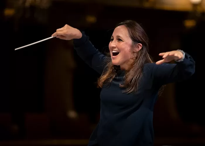 Young woman conductor with her arms in the air