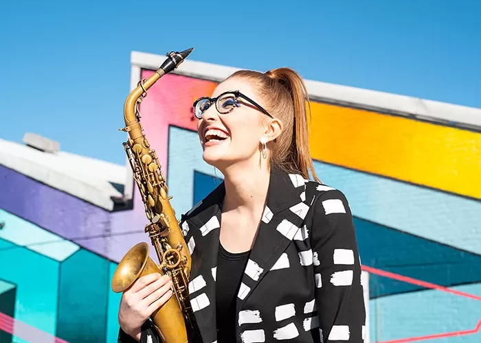 Alto saxophonist Jess Gillam against a colored background