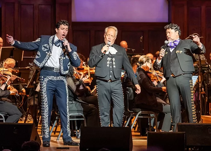 The Three Mexican Tenors in tuxes, on stage with an orchestra