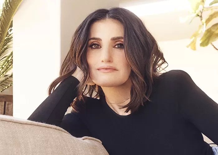 Idina Menzel sitting on a couch