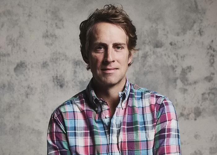 Ben Rector in a brown sweater with his hands held under his chin