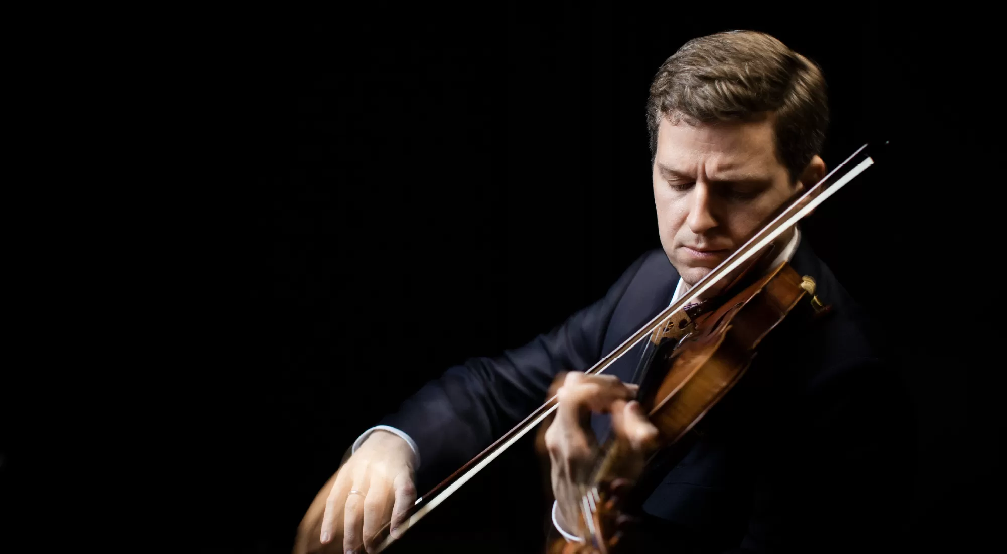 Violinist James Ehnes in a suit holding his violin