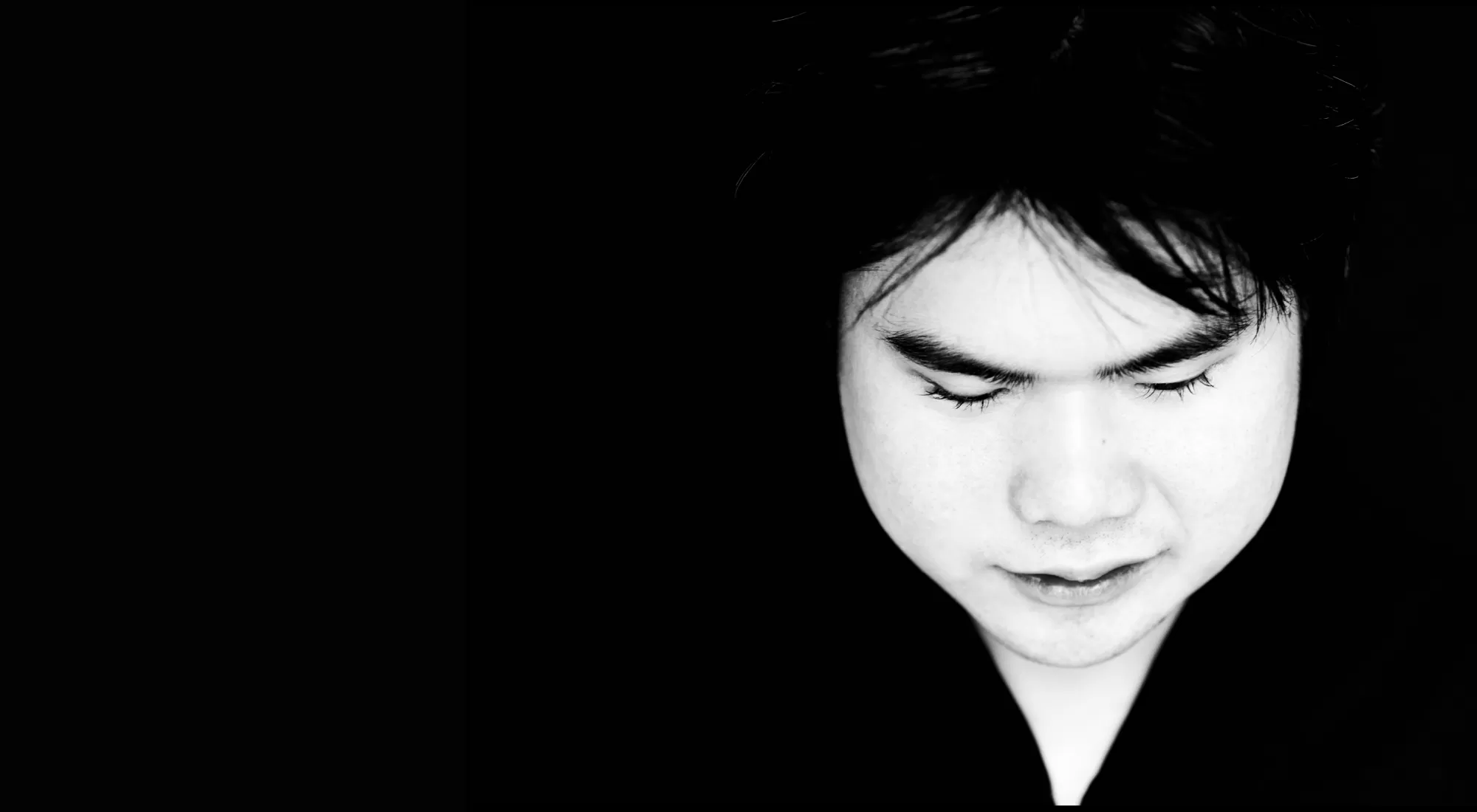 Black and white photo of a young man looking down