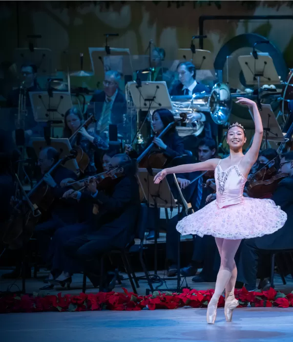 a ballerina dancing in front of an orchestra