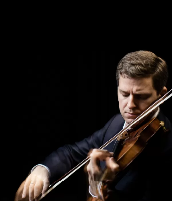 Violinist James Ehnes in a suit holding his violin