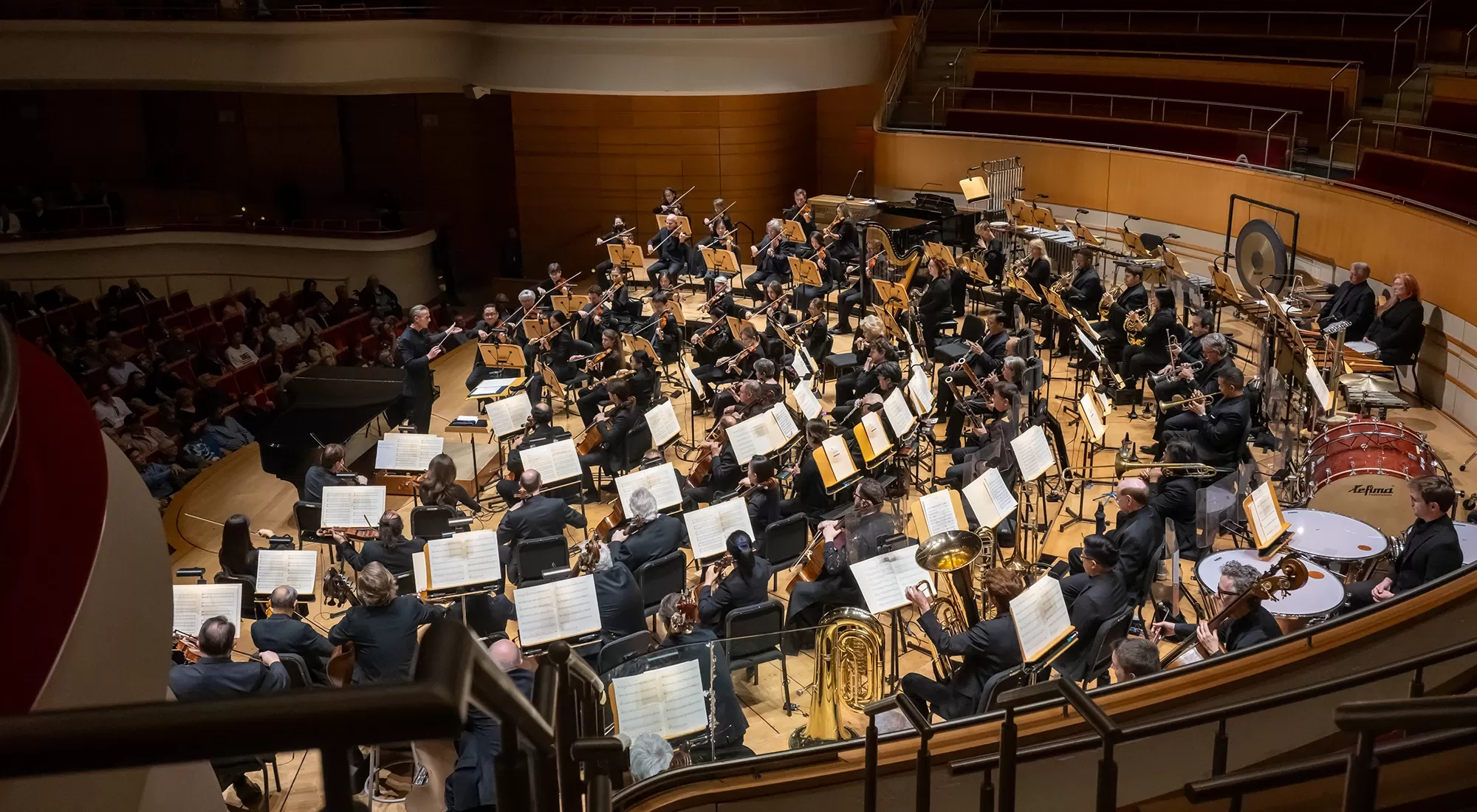 Pacific Symphony on stage with Alexander Shelley conducting viewed from behind the orchestra